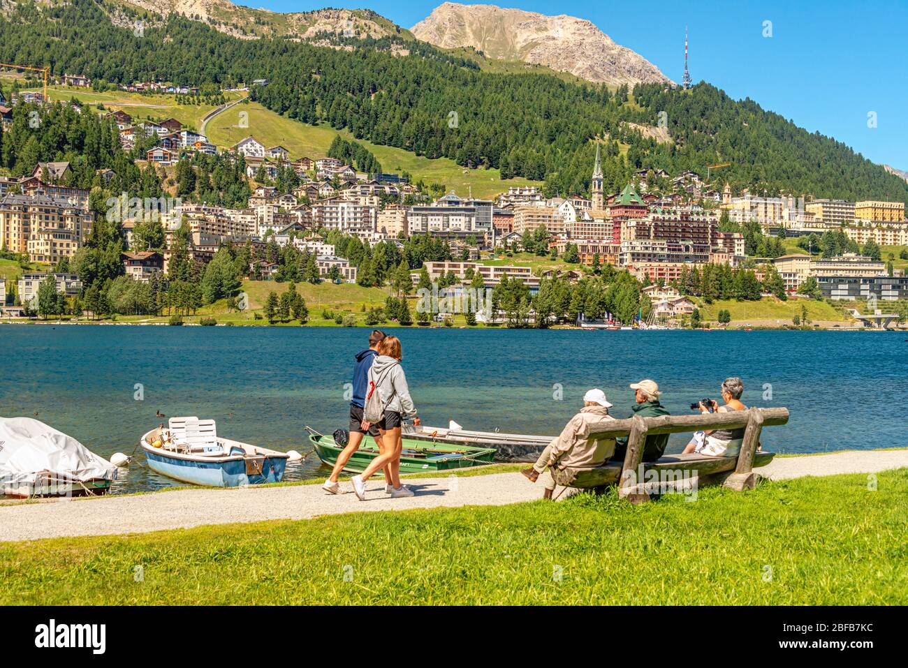 Tourists enjoy the sun at Lake St.Moritz in spring, Upper Engadine, Grisons, Switzerland Stock Photo