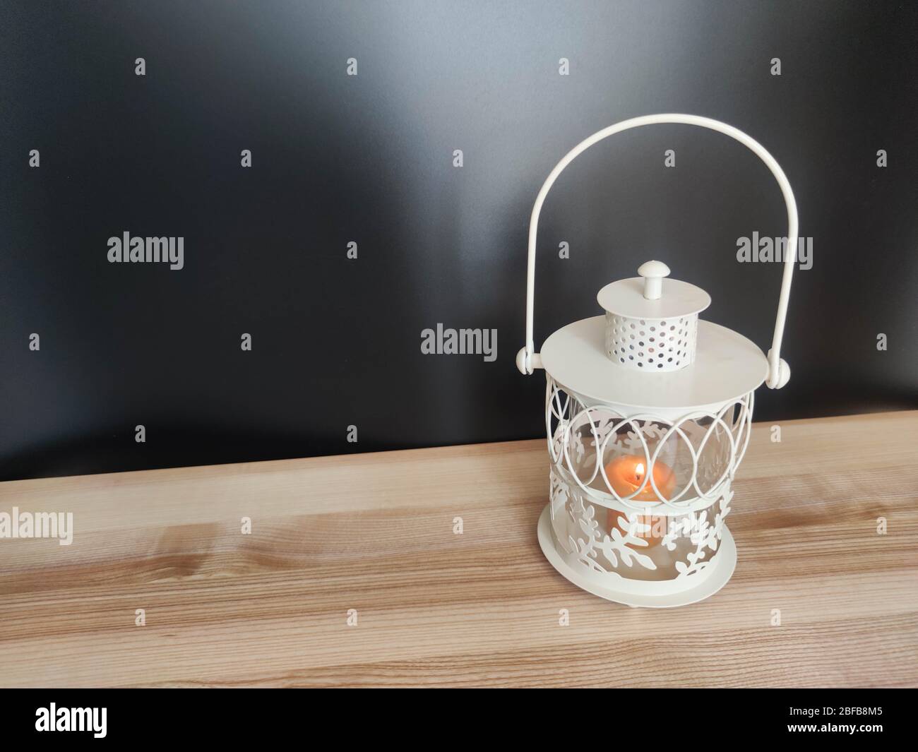 Vintage lantern with an orange candle on the table with black backdrop. Concept - Ramadan kareem holiday celebration. Royalty Free Stock photo Stock Photo