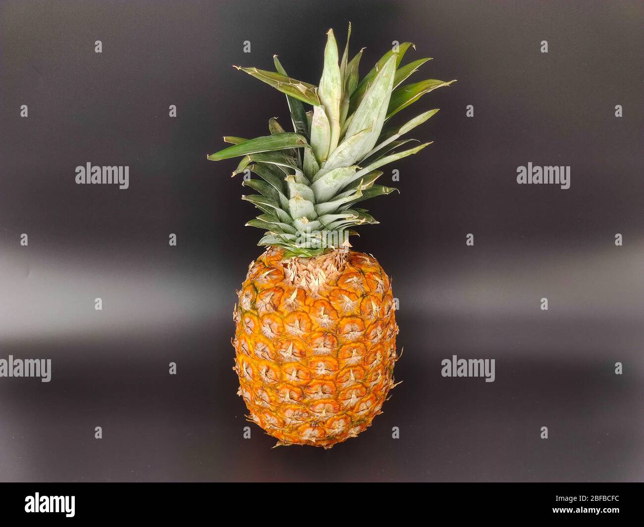A whole pineapple on black. Vegetarian and healthy food. Nutrition and diet background Stock photo Stock Photo