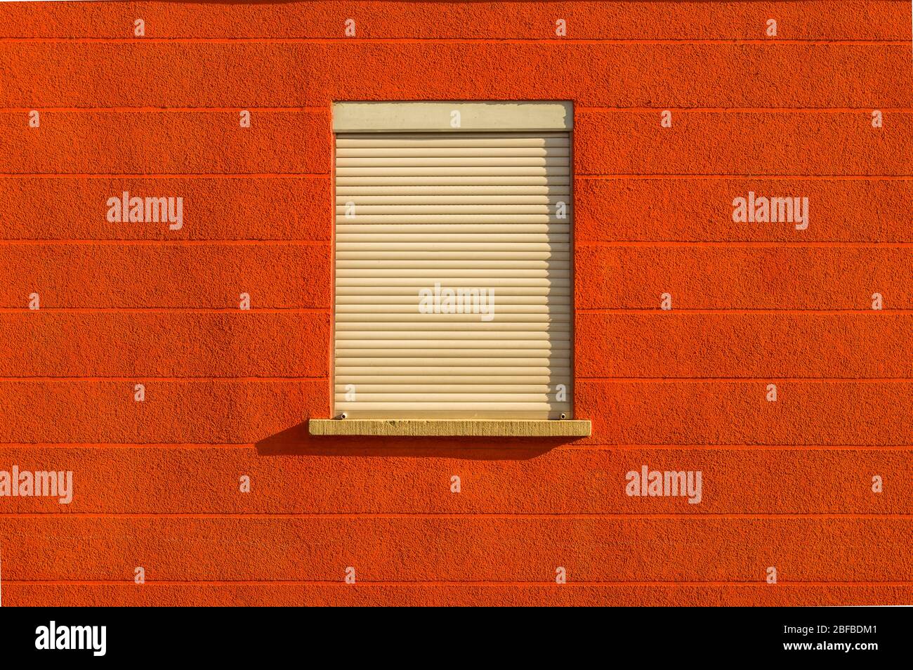 Facade with bright red colors a window blinds centered horizontal line pattern Stock Photo