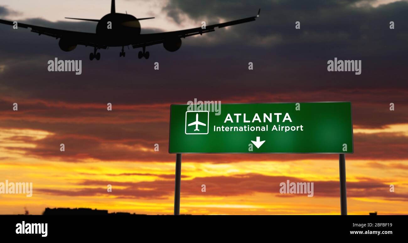 Airplane silhouette landing in Atlanta, Georgia, USA, United States. City arrival with airport direction signboard and sunset in background. Trip and Stock Photo