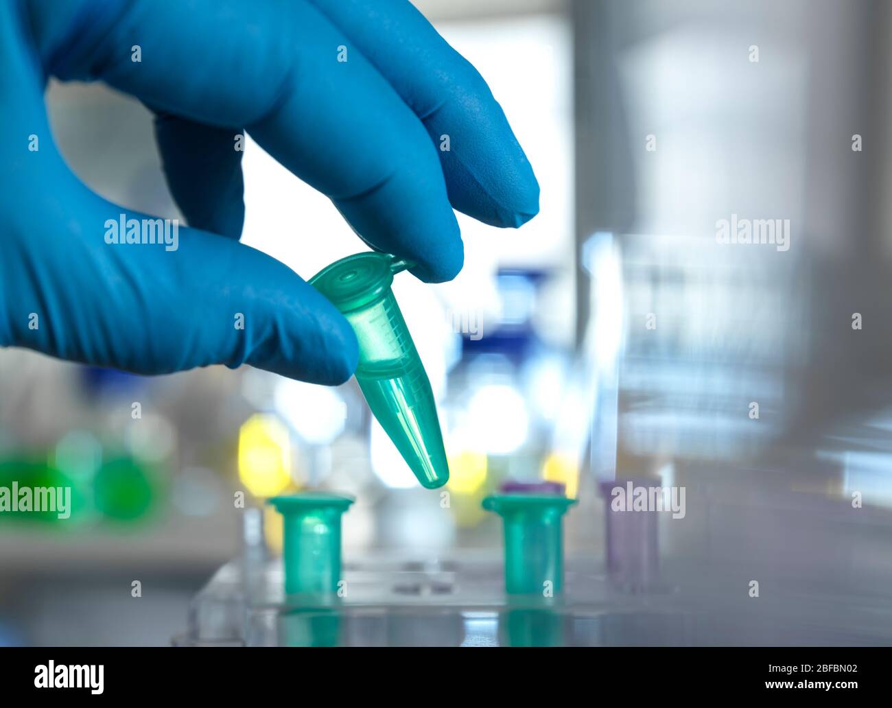 Scientist preparing a sample vial for automated analysis in the lab ...