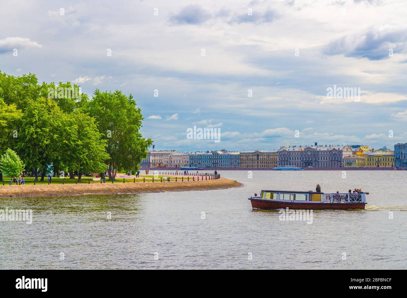 Cityscape of Saint Petersburg Leningrad city with row of old colorful buildings on embankment and boat ship on water of Neva river near Zayachy Hare I Stock Photo