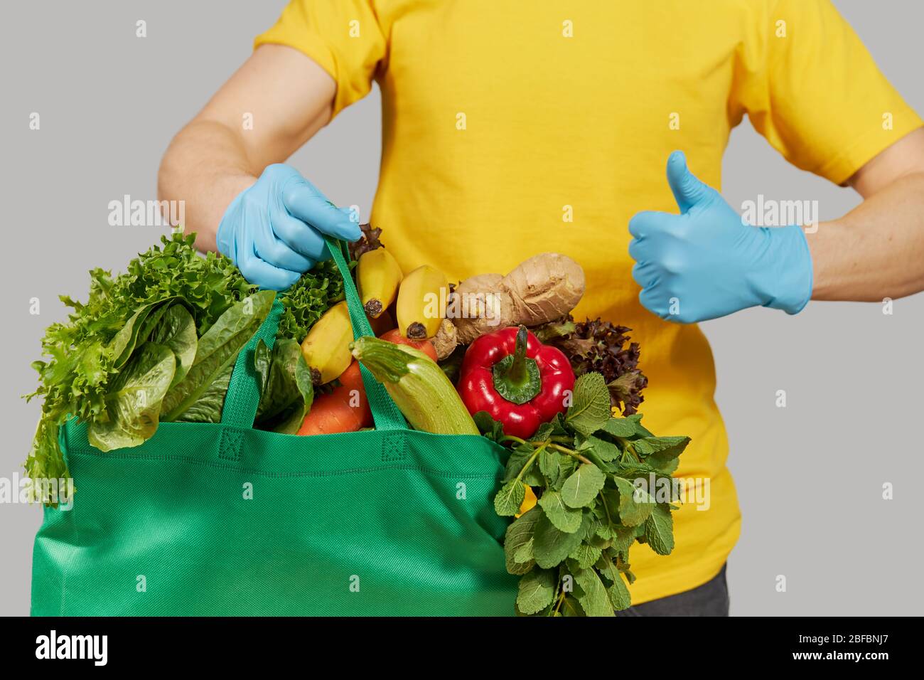 Online Shopping Concept Male Courier In Yellow Uniform Protective Mask And Gloves With A Grocery Box With Fresh Fruits And Vegetables Home Delivery Stock Photo Alamy