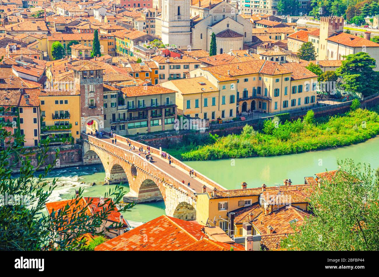 The Ponte Pietra Stone Bridge, Pons Marmoreus, Roman arch bridge across Adige River, buildings with red tiled roofs in Verona historical city centre, Stock Photo