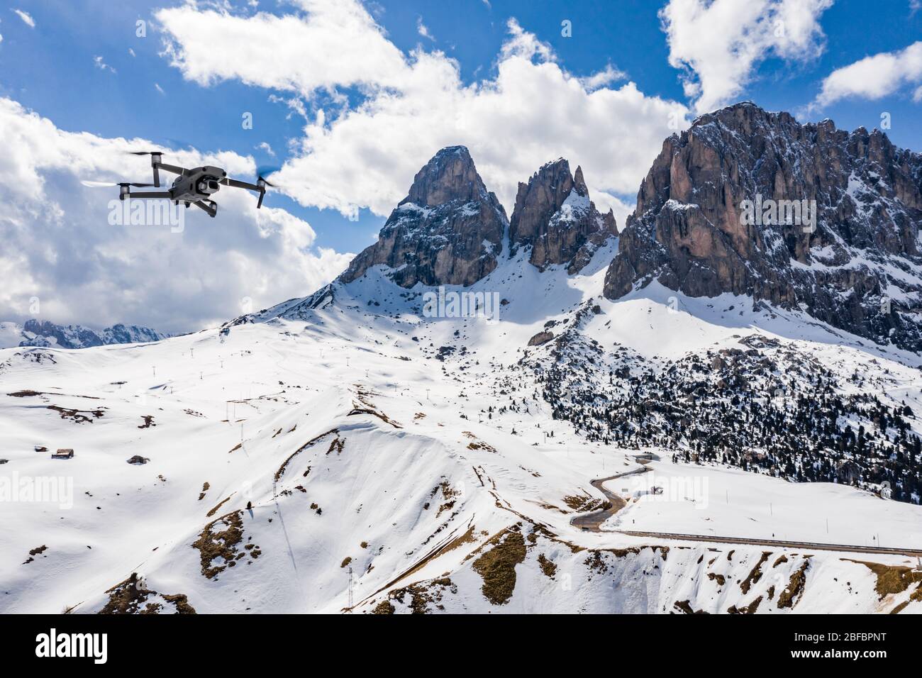 Italy, Dolomites, Canazei, The flying soaring drone hanged over mountains,  on a background snow-covered mountains, the twisting road, the blue sky  Stock Photo - Alamy