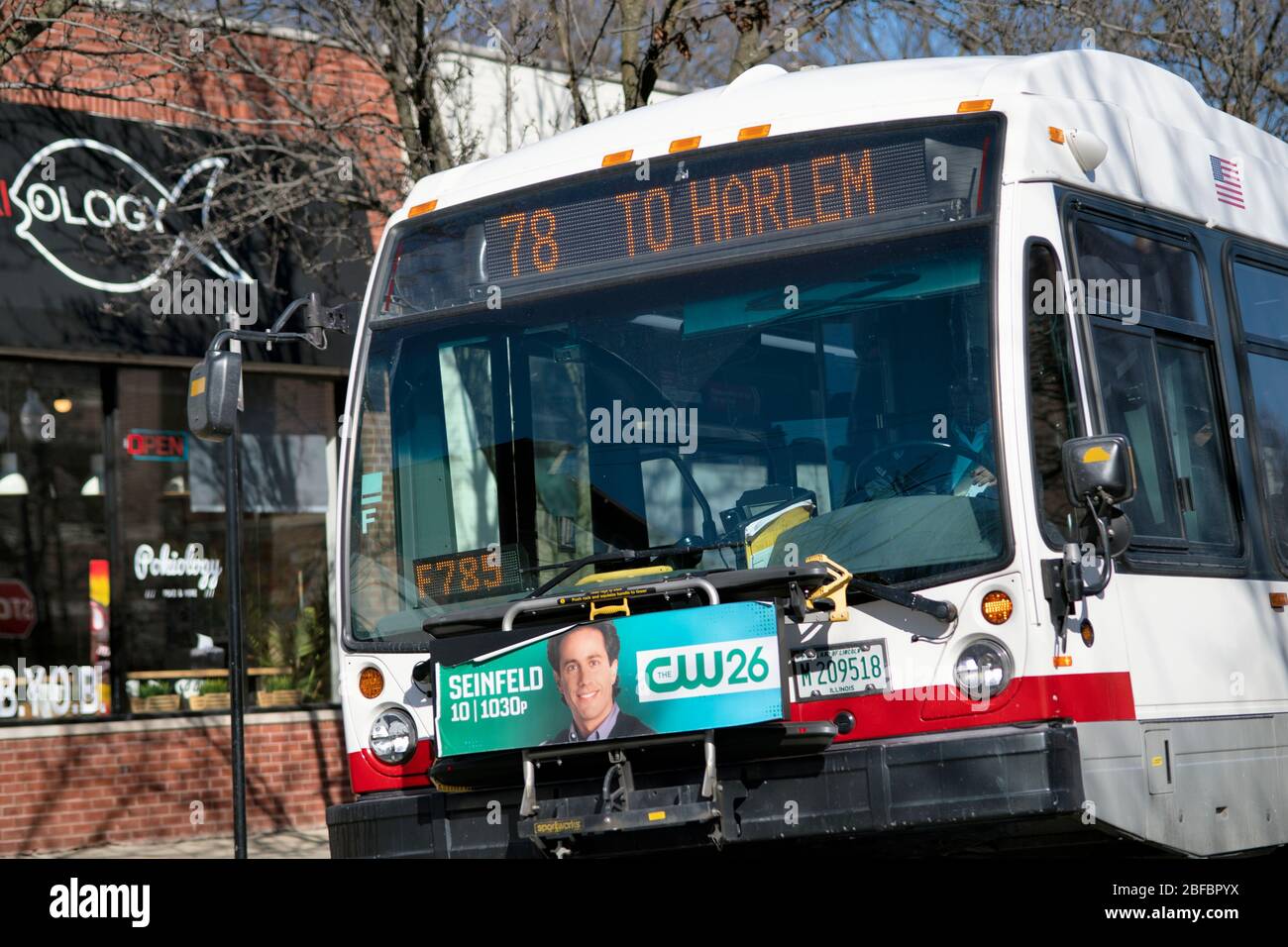 Chicago, Illinois, USA. A CTA bus fitted with a bicycle rack pulling away from a bus stop in the Sheridan Park neighborhood on the city's North Side Stock Photo