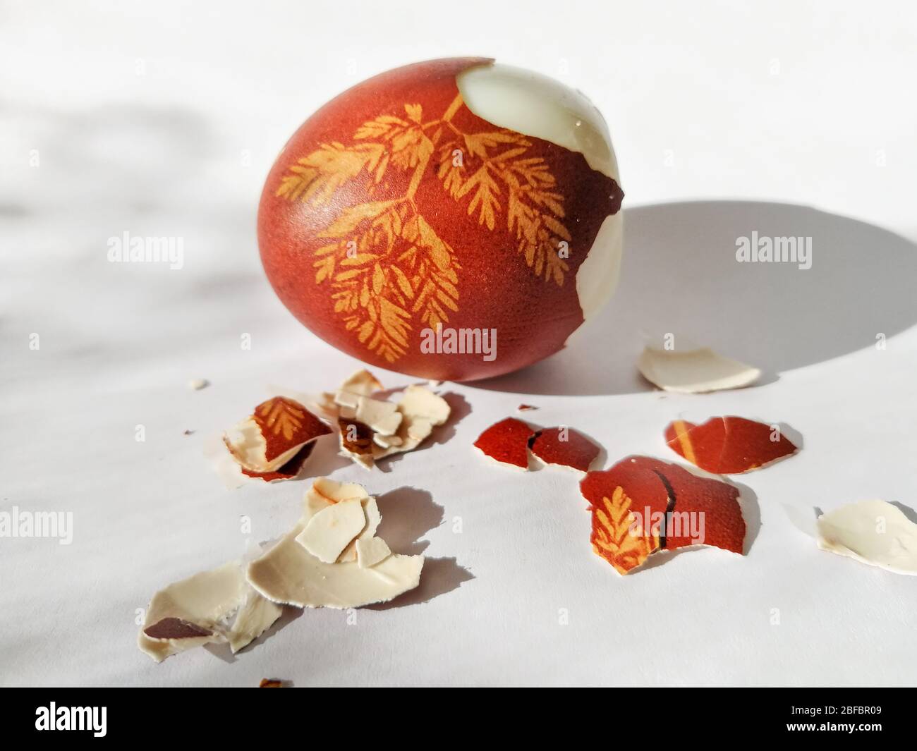 Broken eggshell painted Easter egg isolated on the white background Stock Photo