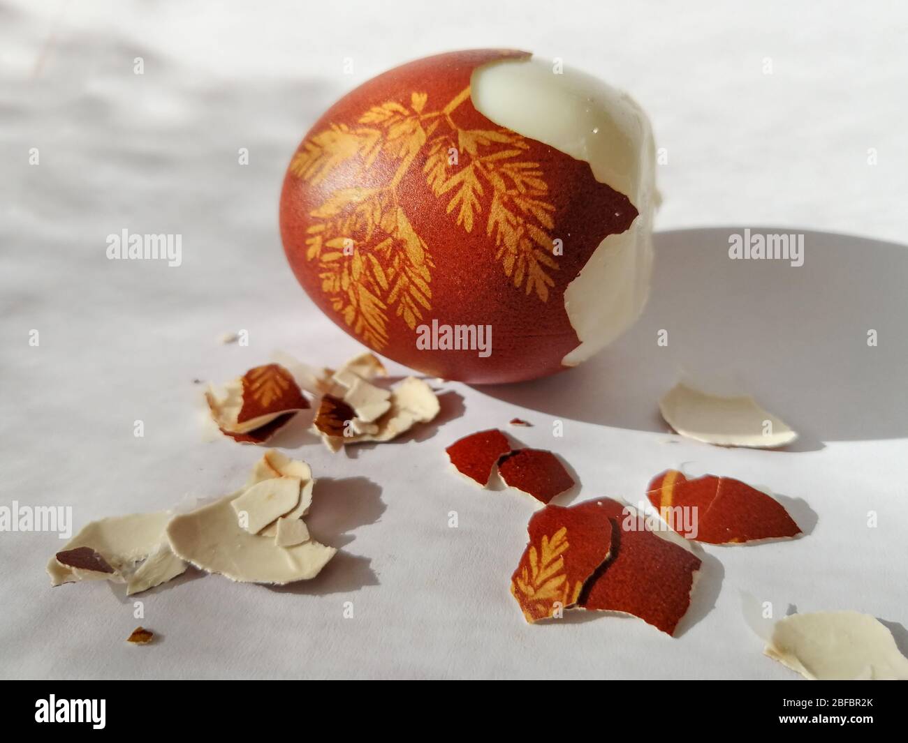 Broken eggshell painted Easter egg isolated on the white background Stock Photo