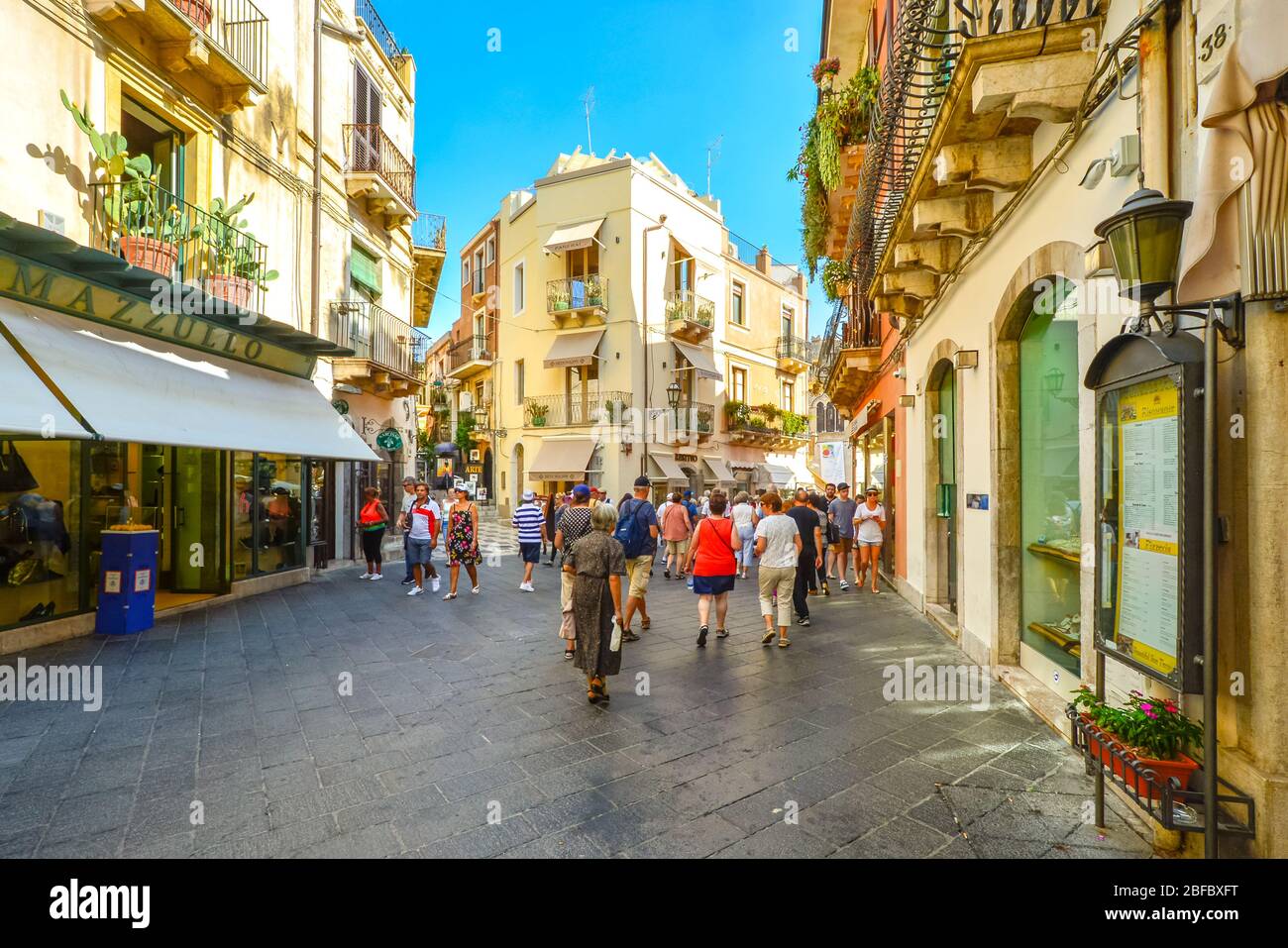 Tourists shop the main street Corso Umberto in old town Taormina on a warm summer day in Sicily, Italy Stock Photo