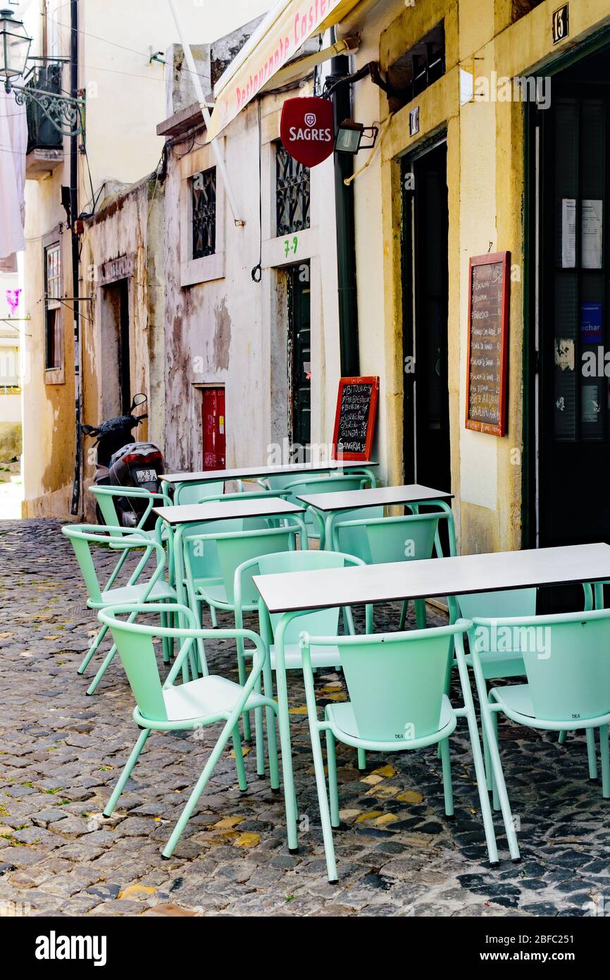 Mint green cafe chairs and tables outside a sidewalk cafe in Lisbon
