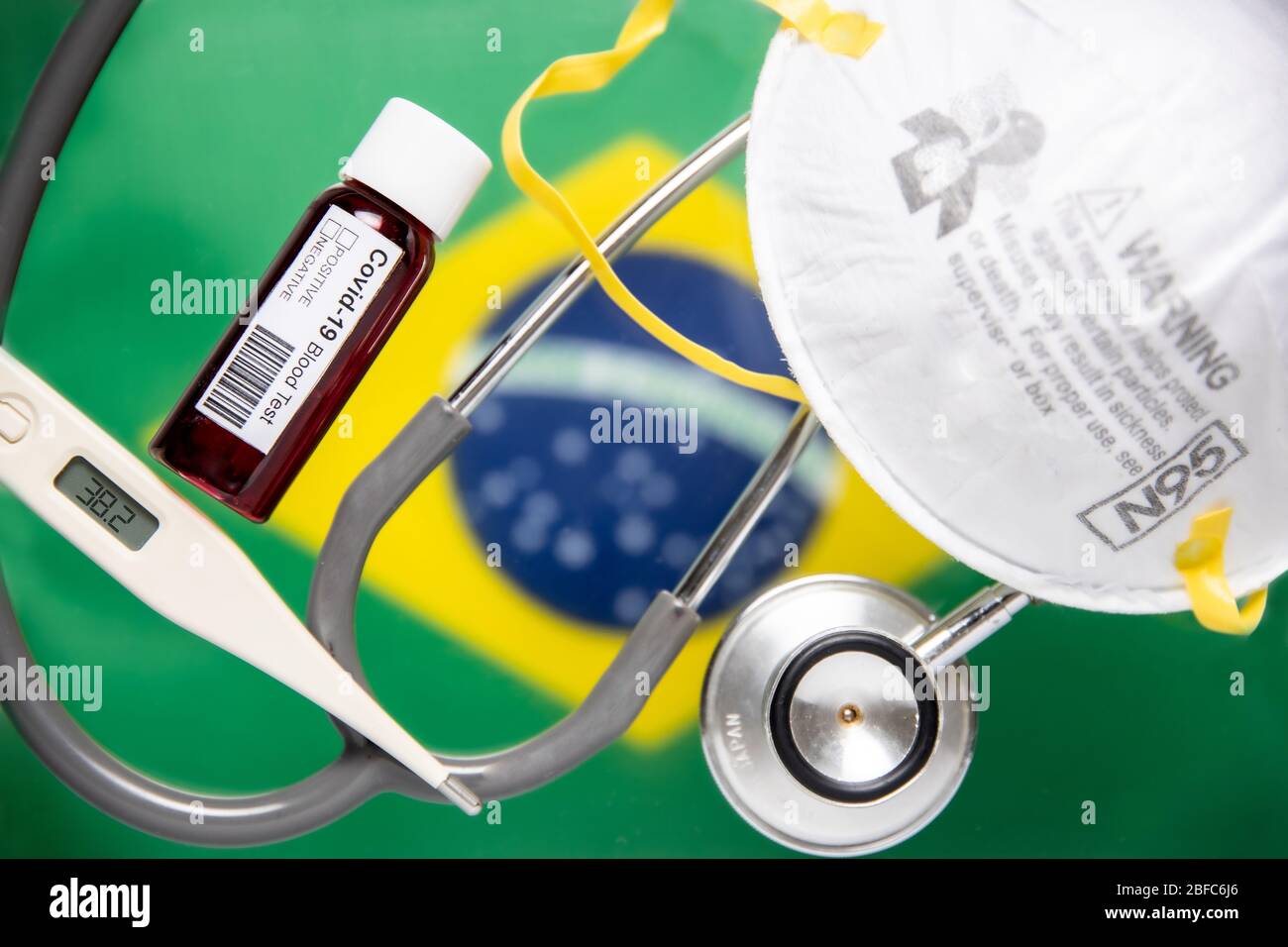 Concept of Coronavirus or Covid-19 pandemic background with Brazil Brazilian Brasil country flag medical blood test, stethoscope, surgical N95 mask Stock Photo
