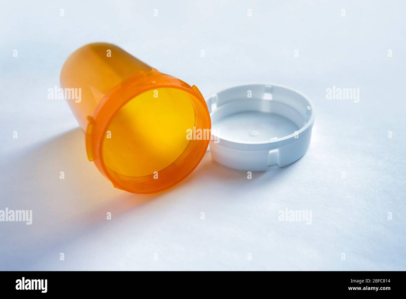 Out of medication empty opened pill bottle on white Stock Photo
