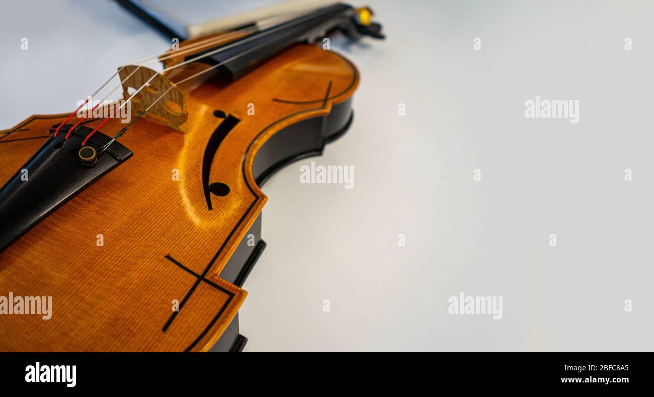 wooden violin  classical stringed instrument placed down on white table Stock Photo