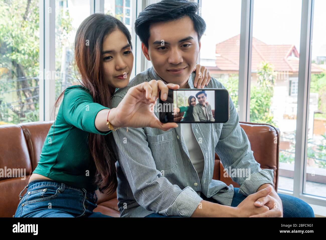 Happy Asian couple enjoy taking selfie photo with mobile phone in ...