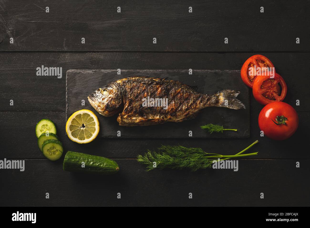 Bream fish with tomatoes, cucumbers and dill. Mediterranean cuisine, healthy eating Stock Photo