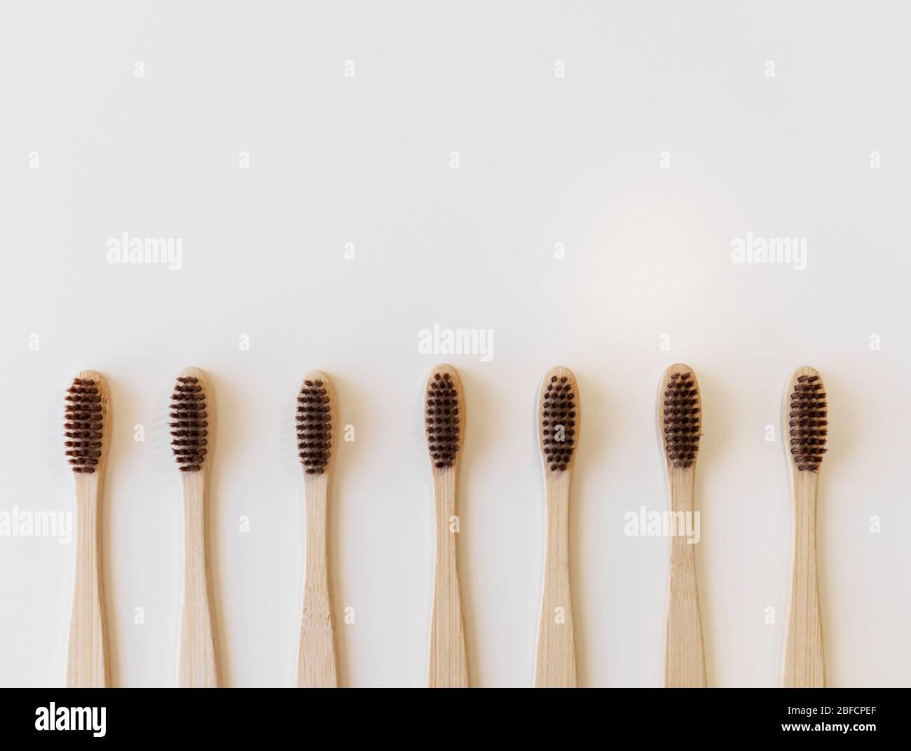 Group of brown eco bamboo toothbrushes, on white background. Top view ...