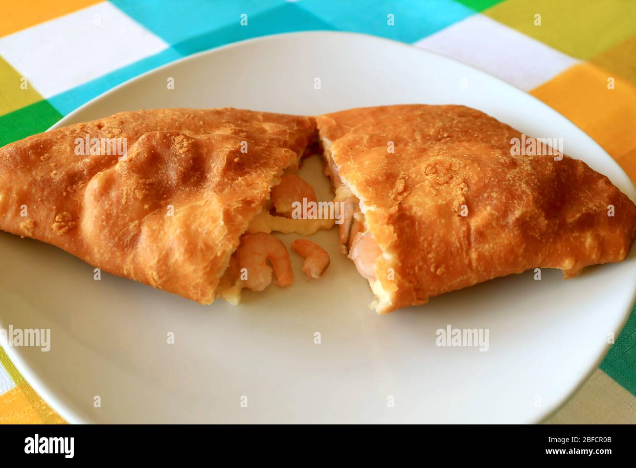 Plate of Empanada de Camarones or Shrimps and Cheese Filled Pastry Cut in Half Stock Photo