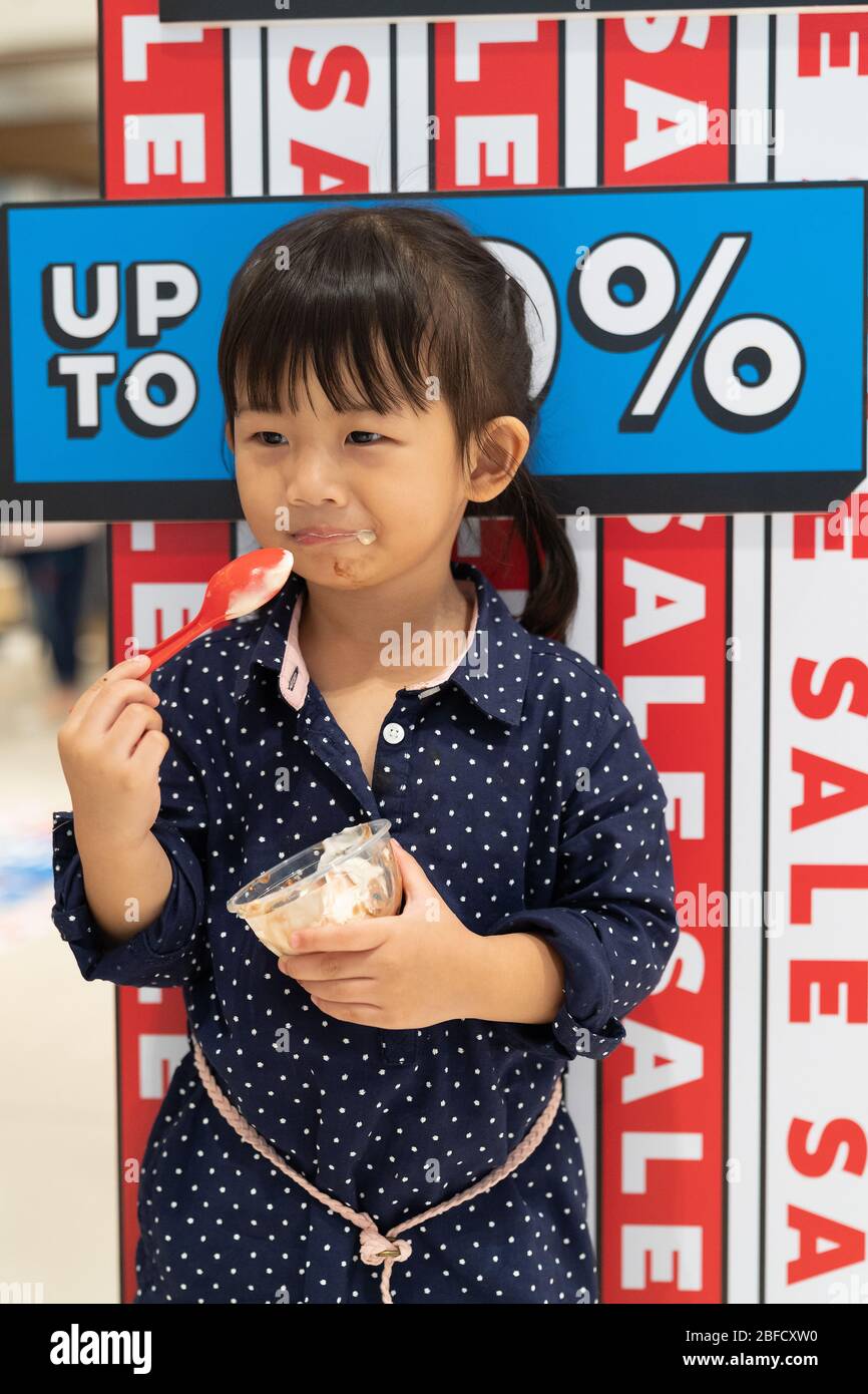 Asian cute girl enjoying with icecream in the shopping mall. Stock Photo