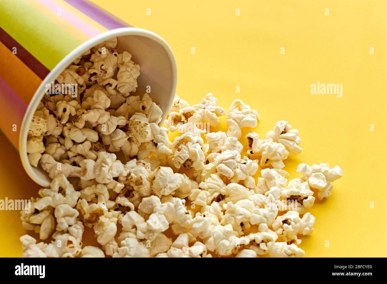 Popcorn in papercup. Multi coloured striped paper cup bucket with ...