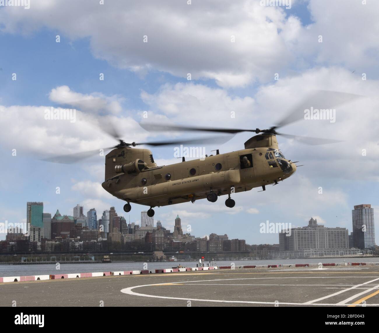 A CH-47 Chinook helicopter, assigned to the New York Army National Guard's Company B, 3rd Battalion, 126th Aviation, approaches a helipad in New York City, April 16, 2020. New York National Guard members are supporting the multi-agency response to COVID-19. (U.S. Air National Guard photo by Senior Airman Sean Madden) Stock Photo