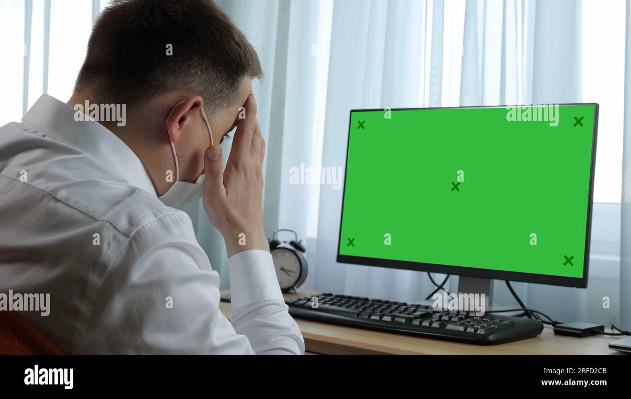 Medium shot. View to the display. Business man watching news on his computer. Green Screen Mock-up Display. Professional shot in 4K resolution. 054. Y Stock Photo