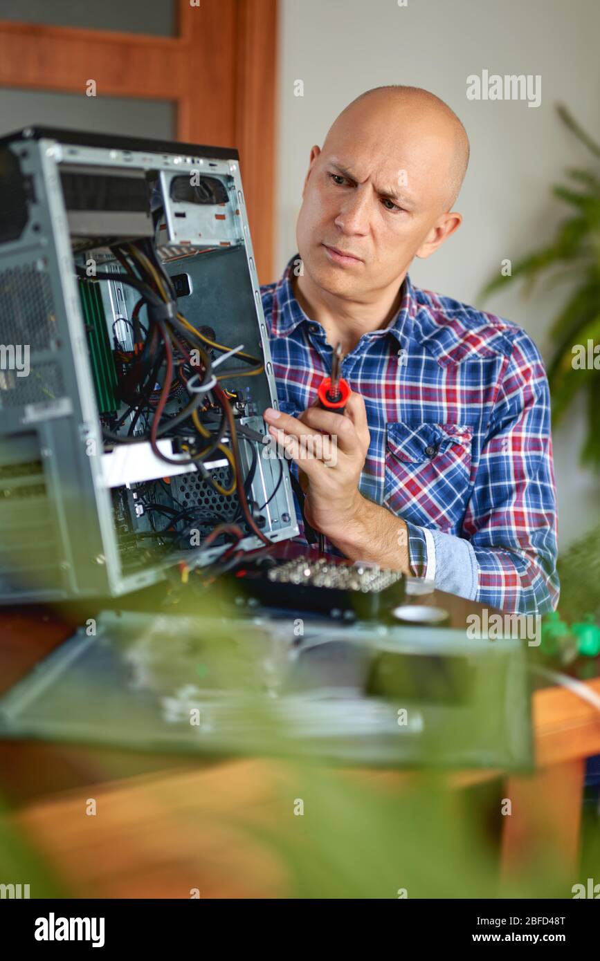 Computer engineer working on broken console at home Stock Photo