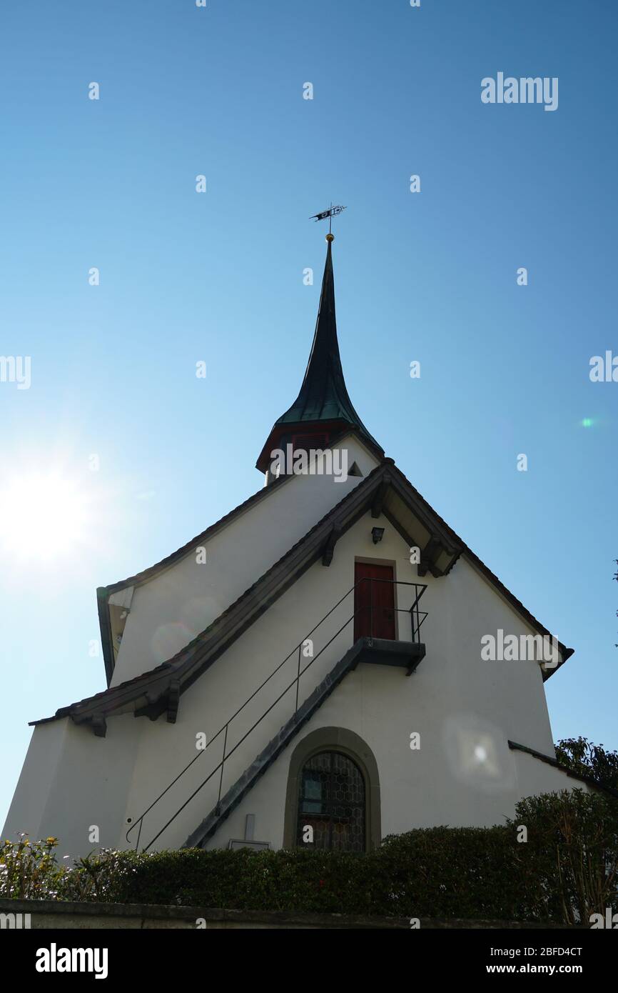 Old reformed church building in Urdorf, lateral view on a clear day, the photo taken in upward perspective. Stock Photo