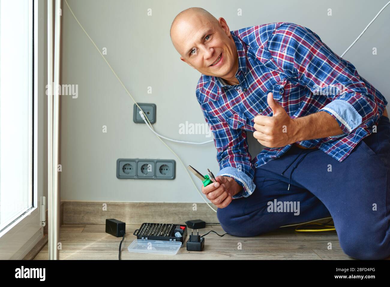 Man installing light switch after home renovation Stock Photo