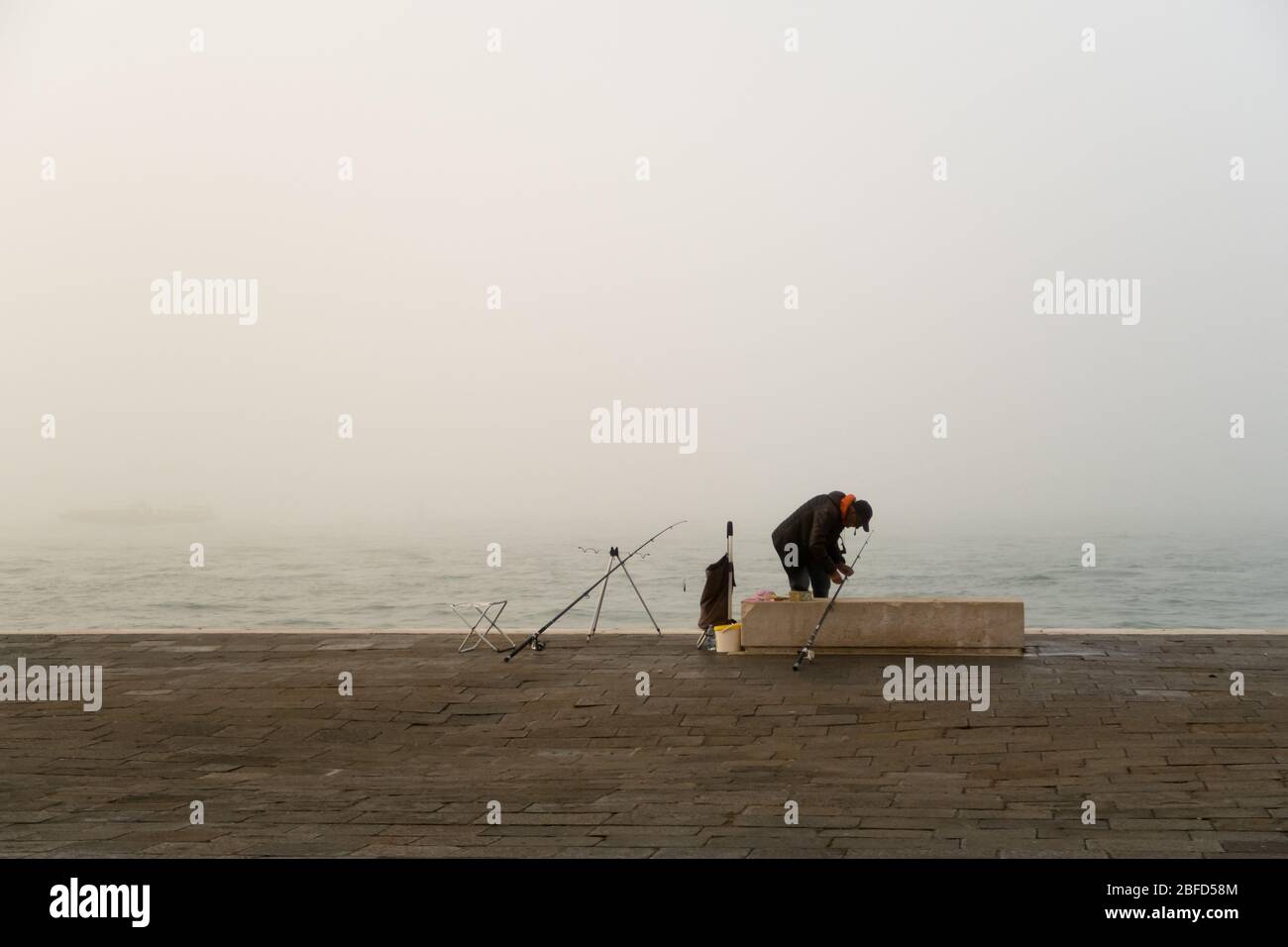 A man fishing on a foggy day Stock Photo