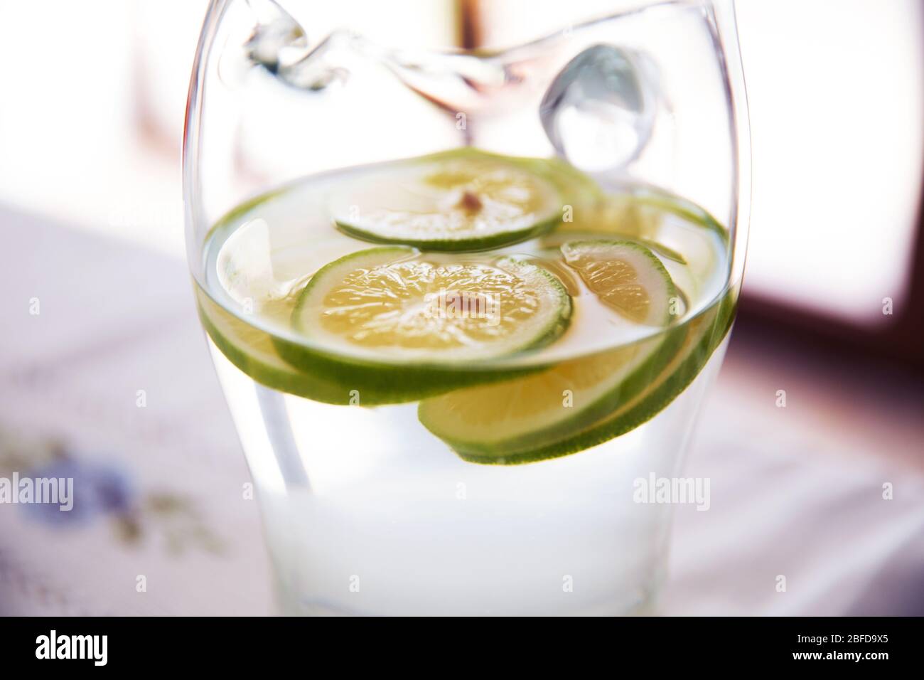Mineral infused water with limes, lemons . Citrus lemonade in glass jur. Lemon in a glass jar . Stock Photo