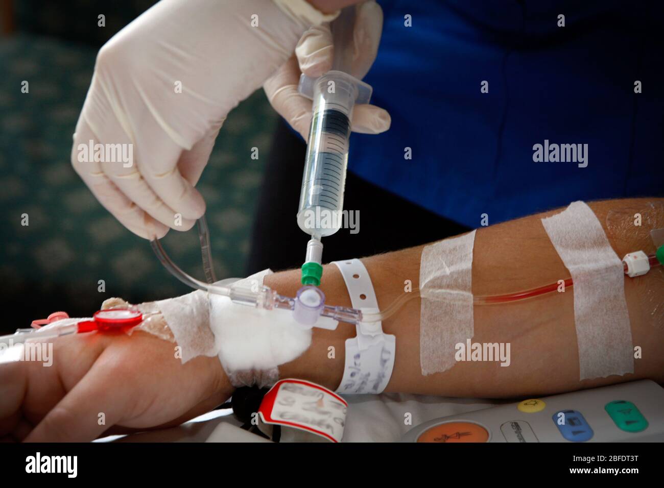 A hospital nurse administrates an antibiotic injection into a catheter