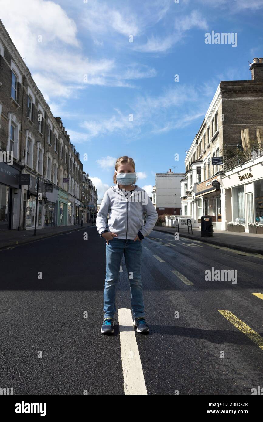 Feeling lonely behind a mask to protect against Corona Virus in an empty street, Fulham Road, London during lockdown, social distancing. Stock Photo