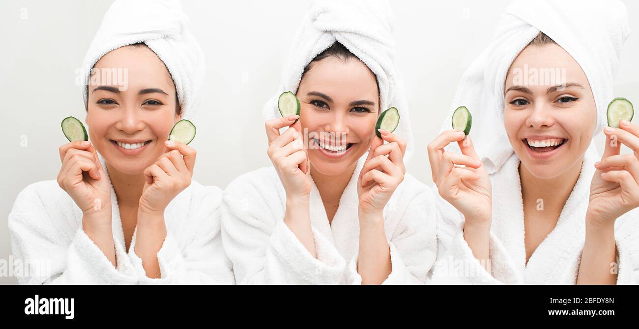 Super cucumber moisturizer face. Three beautiful women, with towels around head holding slices cucumber. Face mask for smooth skin Stock Photo