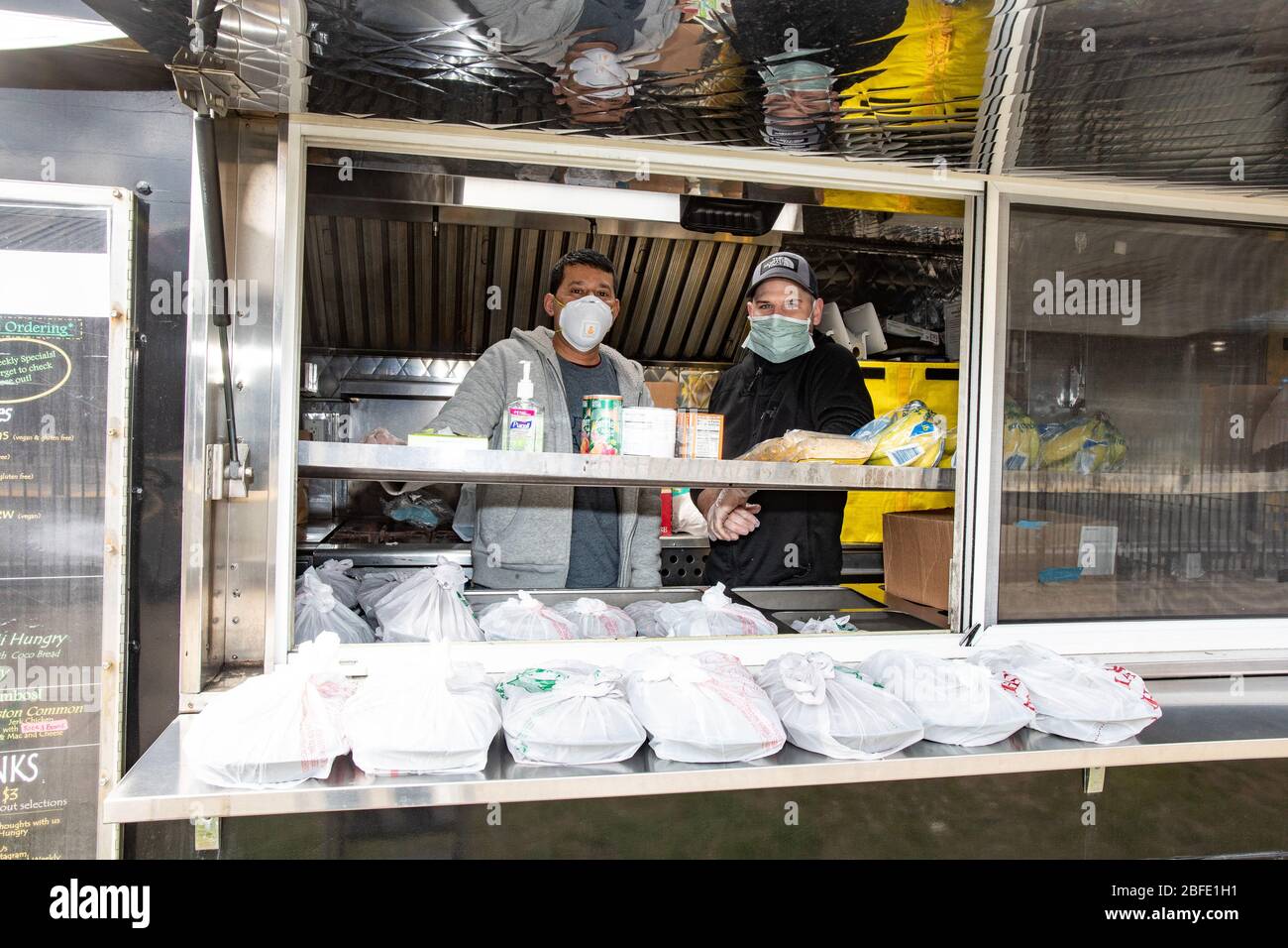 April 16, 2020, Revere, Massachusetts, USA: Staff of Blue Dragon inside the Jamaica Mi Hungry Truck, operating Restaurant relief program truck in Revere.  Blue Dragon owned by Celebrity Chef Ming Tsai and Jamaica Mi Hungry are part of the restaurants working on Restaurant Relief Program to bring meals to the unemployed restaurant workers. Stock Photo