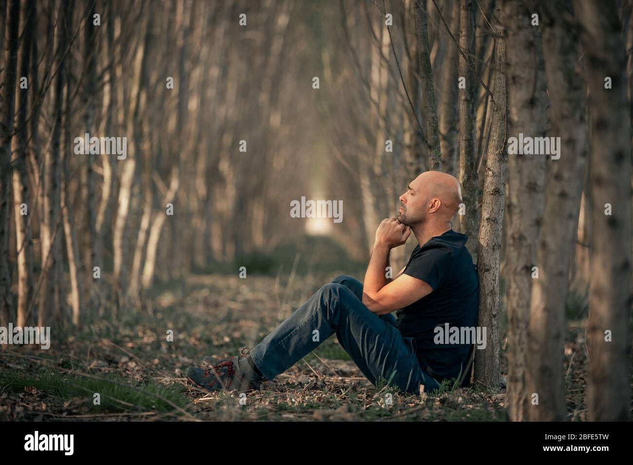 Sitting man with depression going through a rough patch in his life, suffering from mental exhaustion, anxiety, burnout Stock Photo