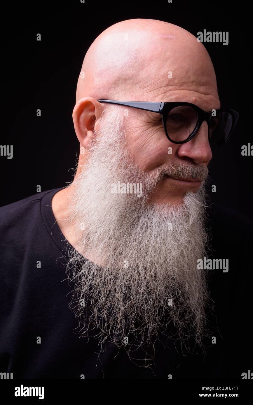 Mature bald bearded man against black background Stock Photo