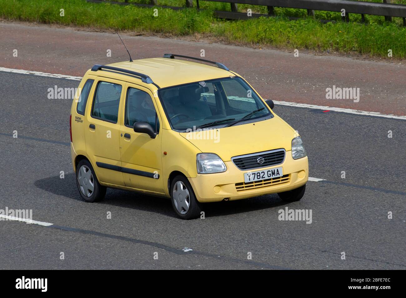 2001 yellow Suzuki Wagon R+ GL; Vehicular traffic moving vehicles, driving vehicle on UK roads, motors, motoring on the M6 motorway highway Stock Photo