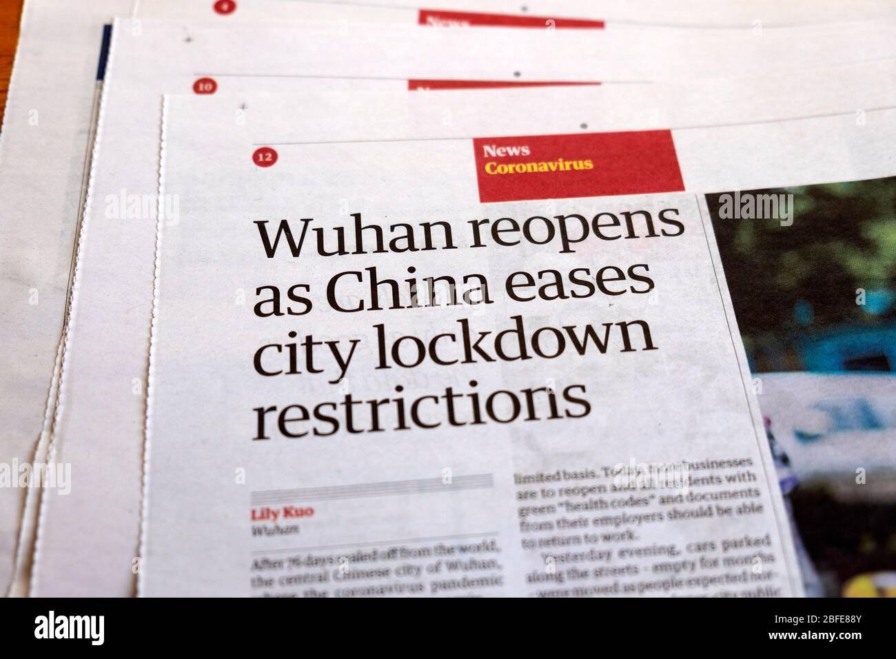 'Wuhan reopens as China eases city lockdown restrictions' Guardian newspaper headline inside page article in April 2020 London England UK Stock Photo