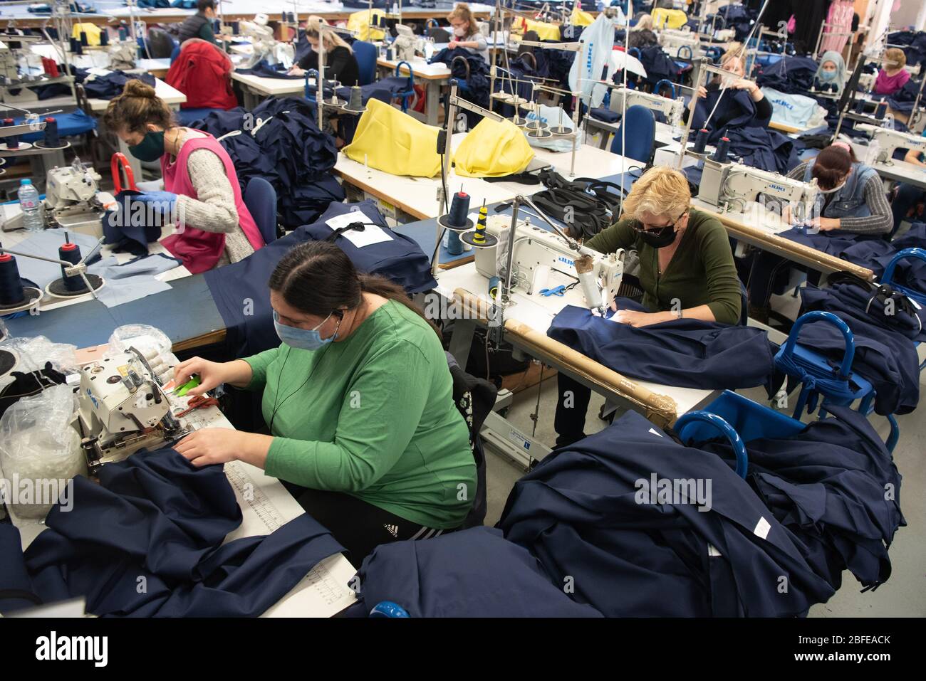 Machinists sew medical clothing for the NHS (National Health Service) at Fashion-Enter Ltd's factory. Stock Photo