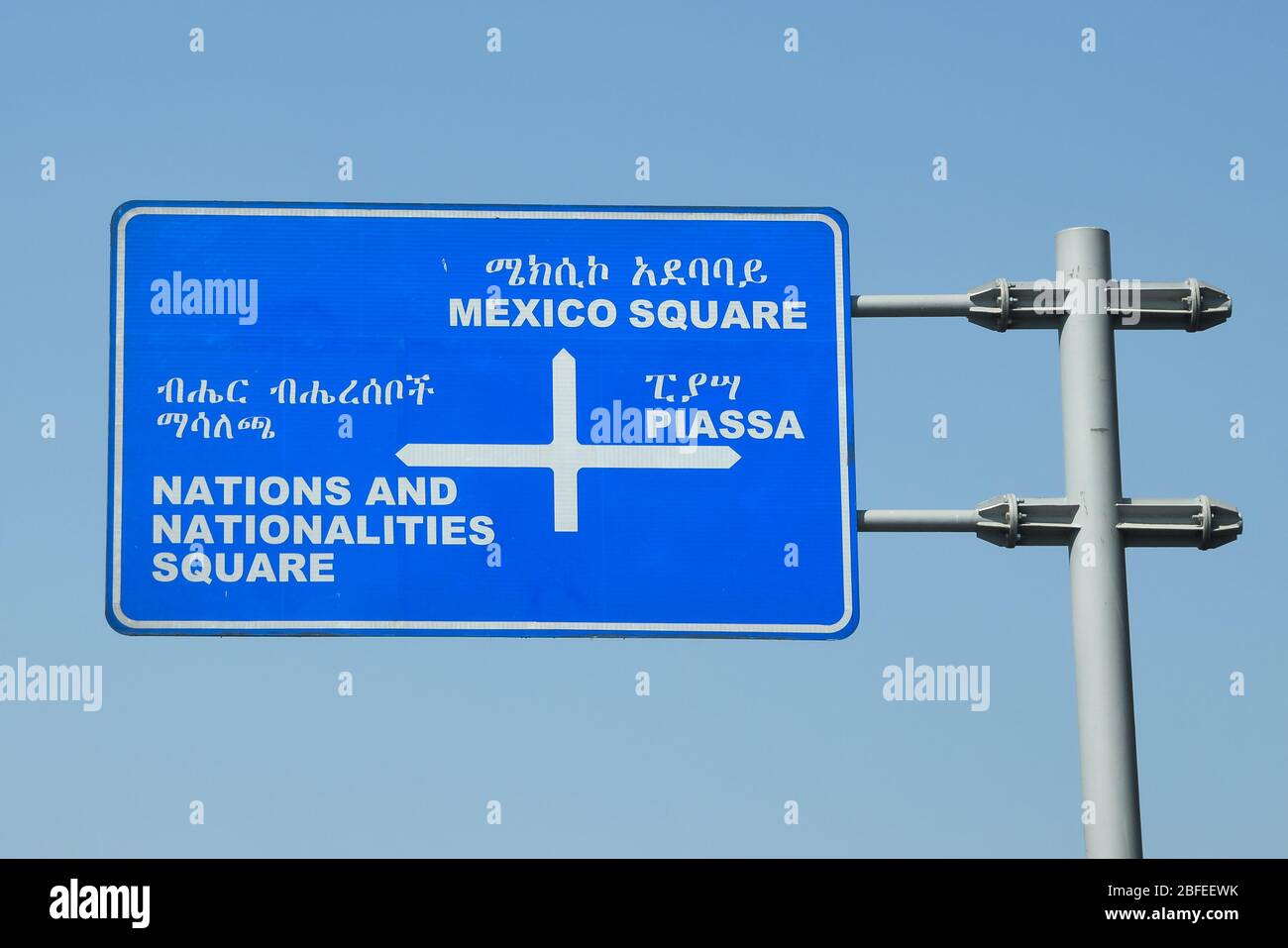 Road sign in Amharic and English language showing directions to Mexico Square, Piassa and Nations and Nationalities Square in Addis Abeba, Ethiopia. Stock Photo