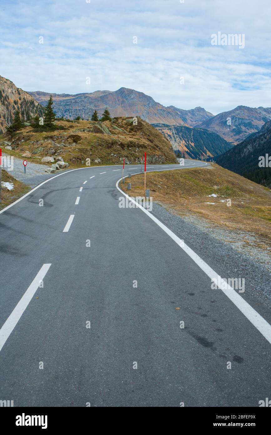Mountain pass road in the alps in autumn with a beautiful view to the surrounding hilltops Stock Photo