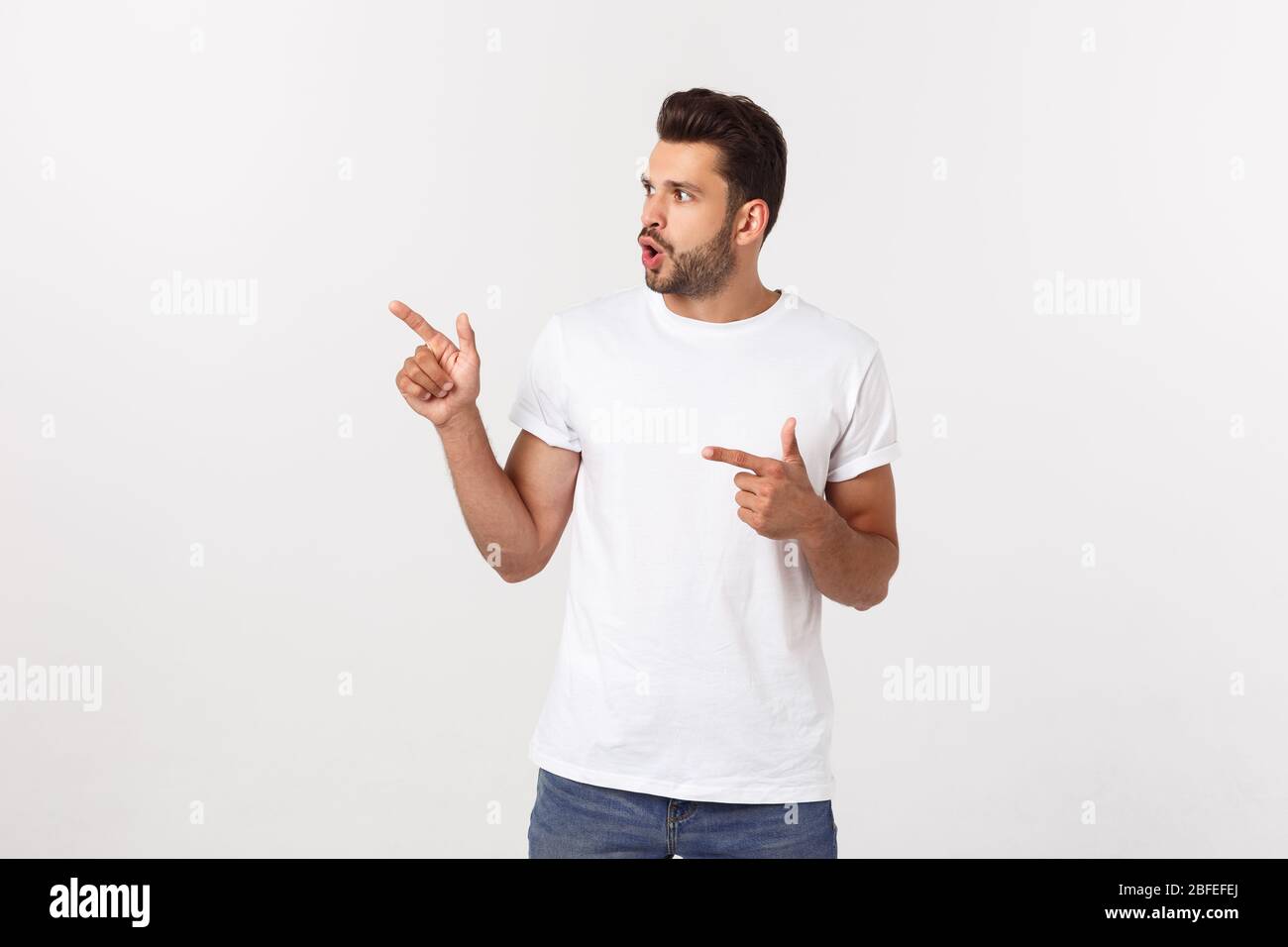 Portrait of an excited happy man pointing finger away at copy space ...
