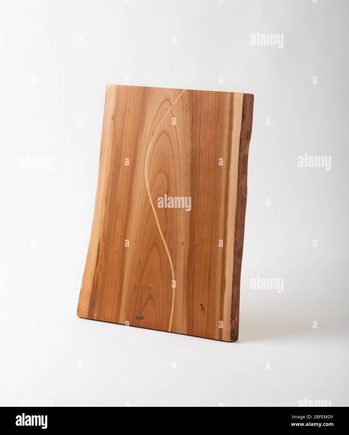 A handmade wooden charcuterie board from cherry wood, with an Sshaped