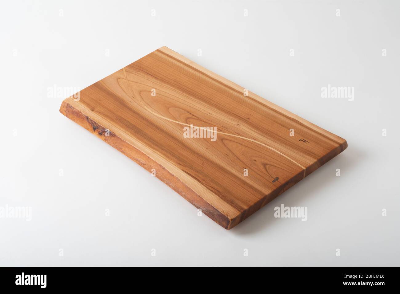 A handmade wooden charcuterie board from cherry wood, with an Sshaped