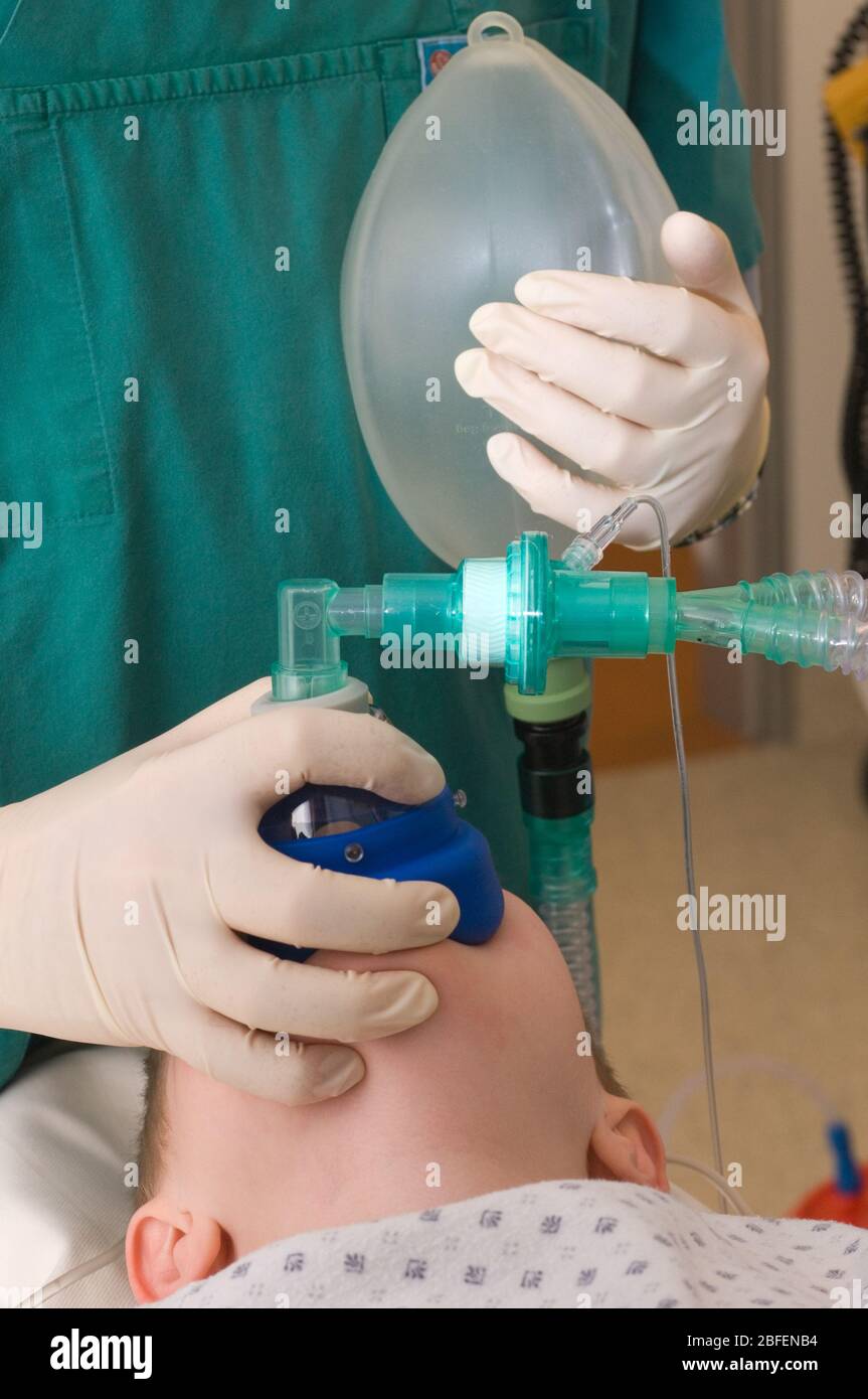 A nurse attaching a resuscitation device to patient during operation Stock Photo