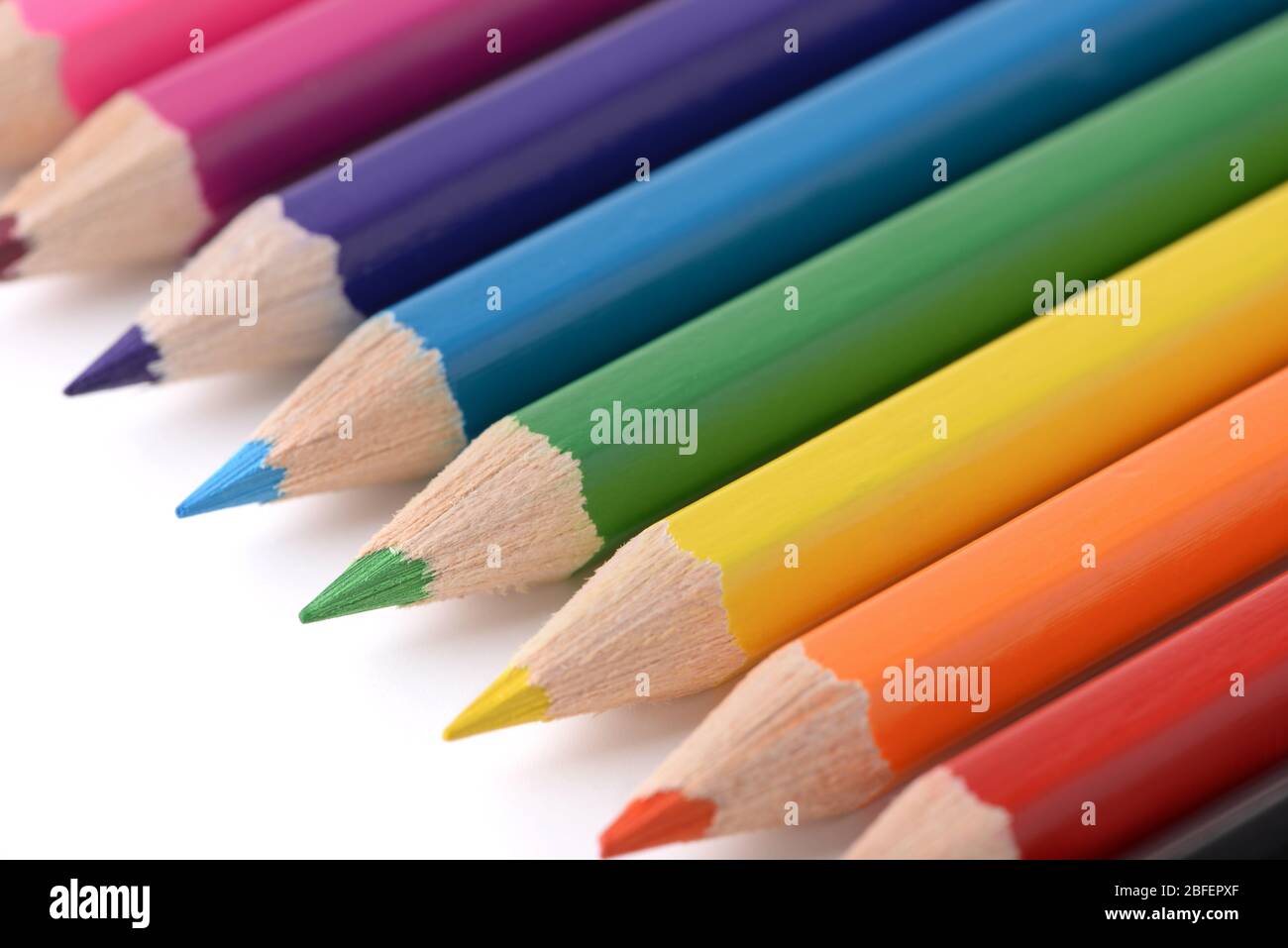 Close up of multicolored pencils in row on white background Stock Photo
