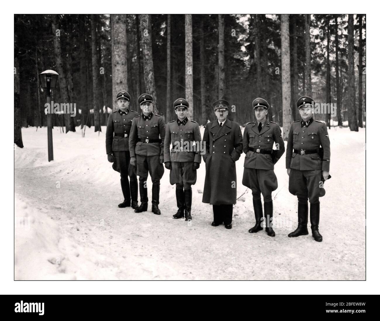 Vintage WW2 1940s Adolf Hitler with earliest members of his personal bodyguard unit, the SS Begleit Kommando: Bruno Gesche on Hitlers immediate left, Erich Kempka on Hitlers immediate right, Adolf Dirr, August Koerber, Franz Schaedle. Photographed at the Wolf’s Lair in winter Eastern Front HQ Poland. Stock Photo