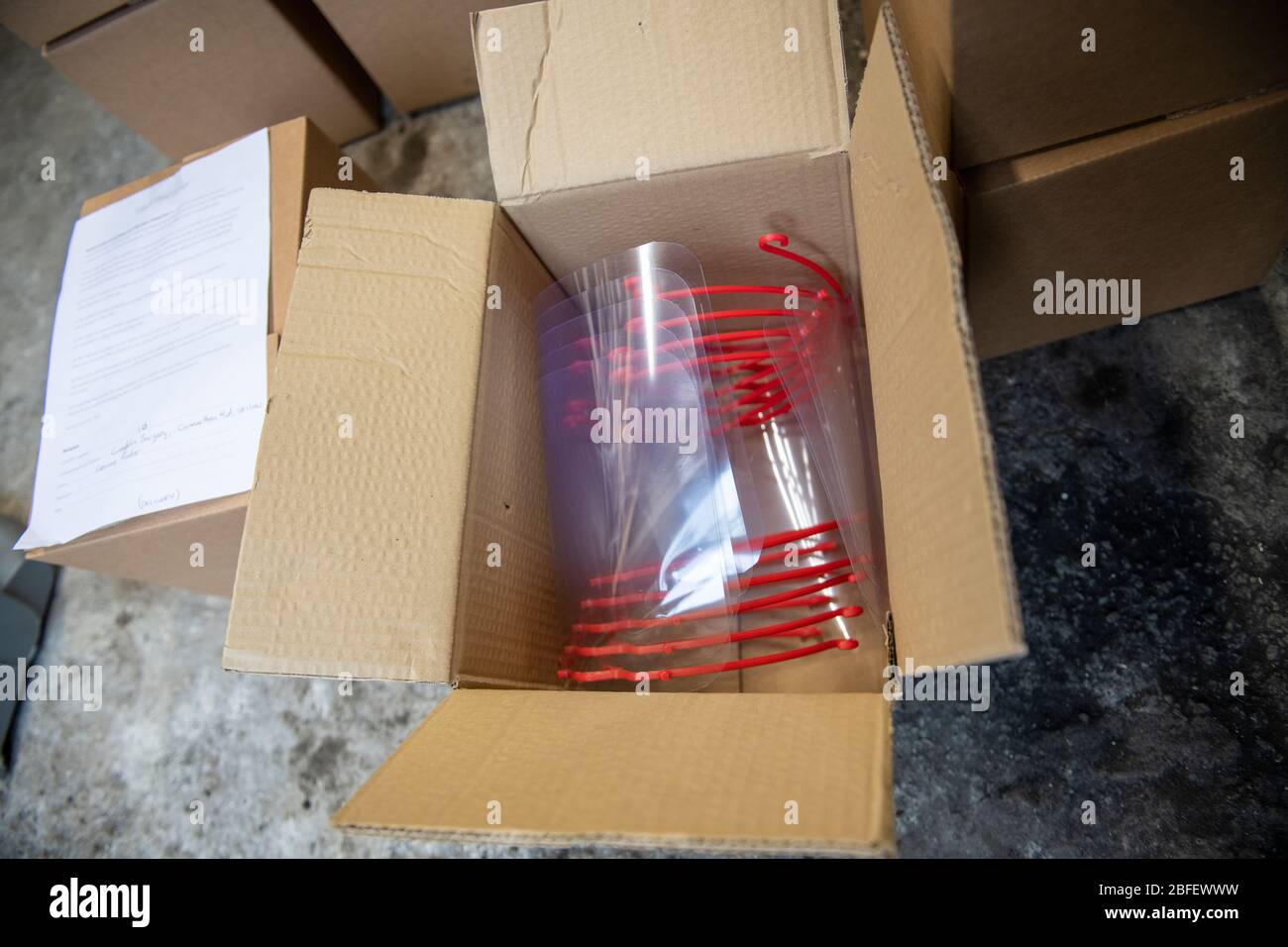 Protective visors delivered in boxes to be distributed to local healthcare workers in South Wales during the Covid pandemic crisis. Produced partially Stock Photo