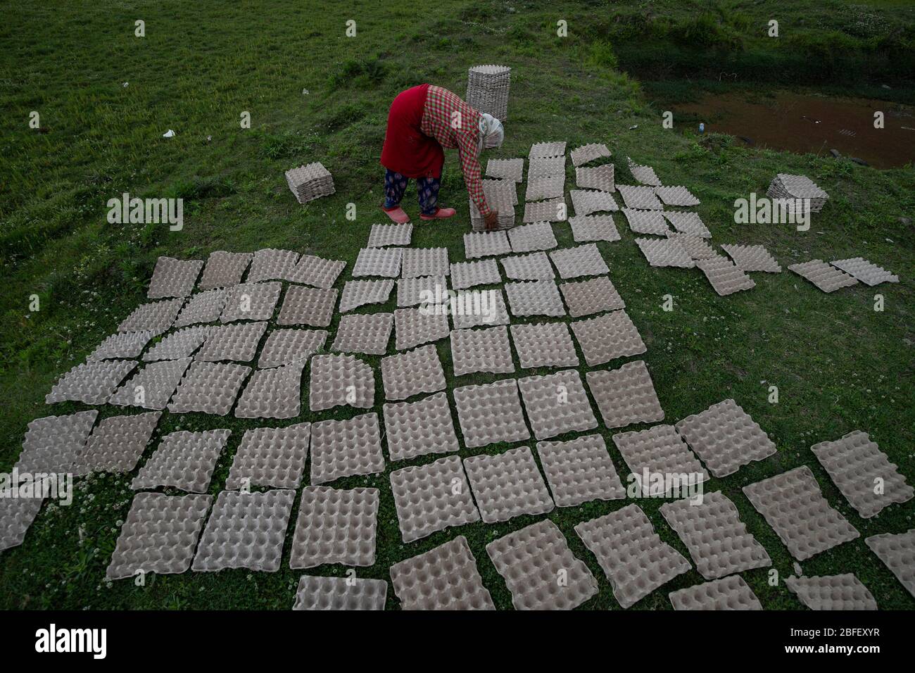 Kathmandu, Nepal. 18th Apr, 2020. A woman collects egg crates from the sun during lockdown.Twenty sixth day of a nationwide lockdown imposed by the government amid concerns about the spread of the coronavirus disease (COVID-19). Credit: SOPA Images Limited/Alamy Live News Stock Photo